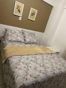 um quarto com uma cama com um edredão floral em Flat Biarritz em São Luís com excelente localização! em São Luís