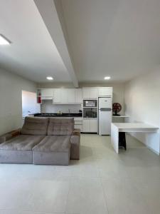 a living room with a couch and a kitchen at Residencial Helena in Porto Belo