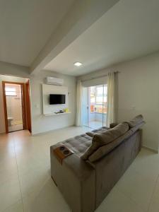 a living room with a couch and a television at Residencial Helena in Porto Belo