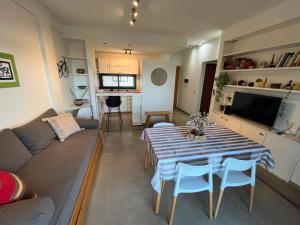 uma sala de estar com uma mesa e um sofá em Semipiso premium con piscina y cochera opcional em La Plata