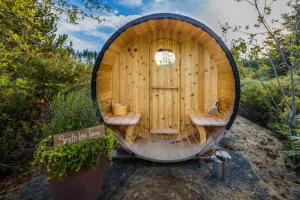 MervilleTiny house & Sauna on Lakefront Farm Oasis的门前设有2张长椅的小木屋