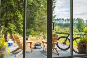 d'une terrasse avec une table, des chaises et un vélo. dans l'établissement Tiny house & Sauna on Lakefront Farm Oasis, à Merville