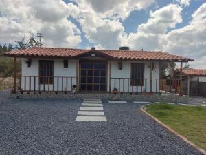 een klein wit huis met een rood dak bij Villa Claudia in Villa de Leyva