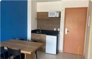 a kitchen with a counter and a sink and a refrigerator at Quarto hotel Thermas São Pedro in São Pedro