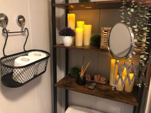 a bathroom with a shelf with a mirror and candles at Charming Pheonix Parkside Flat in Dublin