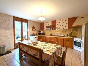 a kitchen with a table with chairs and a tablecloth on it at Gîte Saulmory-Villefranche, 4 pièces, 6 personnes - FR-1-585-15 