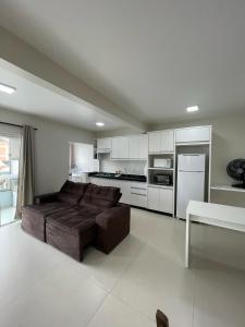 a large living room with a couch and a kitchen at Residencial Helena in Porto Belo