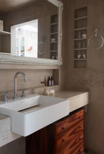 a bathroom with a white sink and a mirror at Apartamento único no coração do Jardim Botânico in Rio de Janeiro