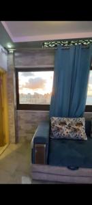 a blue couch in a room with a window at Sea View Studio alexandria in Alexandria