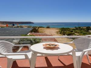 a table and two chairs on a balcony with the ocean at Alojamento Mareta in Sagres