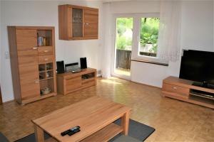 a living room with a television and wooden furniture at Haus am Waldrand in Triberg