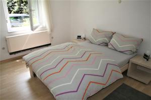 a bedroom with a large bed with a striped blanket at Haus am Waldrand in Triberg