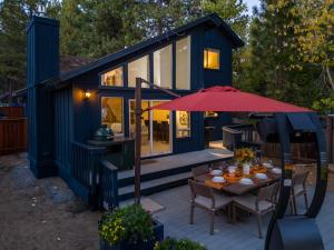 a blue tiny house with a table and an umbrella at Waves End Lakefront - 3BR Tahoe Vista w Private Sandy Beach, Walk to Town! in Tahoe Vista
