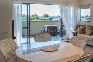 a living room with a table and chairs with a view at Ohope Beach TOP 10 Holiday Park in Ohope Beach