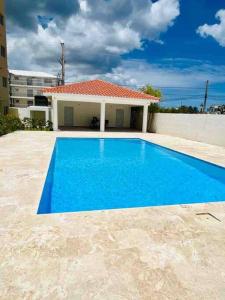 een blauw zwembad voor een huis bij Hermoso apto de playa, La romana. in La Romana
