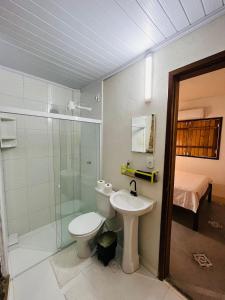 a bathroom with a toilet and a sink and a shower at CASINHA FLOR, no centro histórico!!! in Piranhas