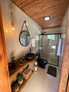 uma casa de banho com um lavatório, um espelho e um chuveiro em Cabana Santo Reffúgio em Urubici