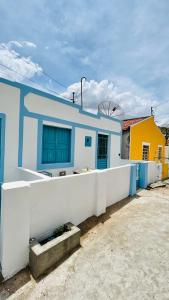 a blue and white building with a white fence at CASINHA FLOR, no centro histórico!!! in Piranhas