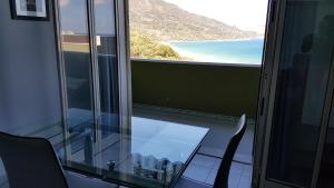 uma sala de vidro com uma mesa e vista para o oceano em CH Exclusive Apartments em Cefalù