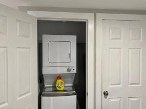 een kleine keuken met een magnetron en een toilet in een kamer bij Hidden Getaway, BSMT with Back Yard in Halifax