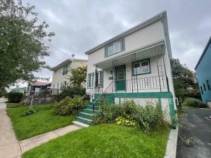 una casa bianca con una porta verde e scale di Cozy 2-BDRM, Mid Floor, Backyard a Halifax
