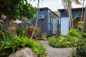 una casa azul con muchas plantas en Cairns City Backpackers Hostel en Cairns