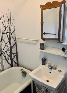 哈利法克斯的住宿－Relaxing Retreat #1，浴室配有盥洗盆、镜子和浴缸