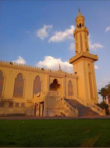 a large building with a clock tower and stairs at شقة في قلب القاهرة الجديدة تطل على شارع التسعين الشمالي in Cairo