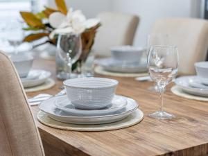- une table en bois avec des assiettes et des verres à vin dans l'établissement Piri at Pearl Autumn Special, à Pearl Beach
