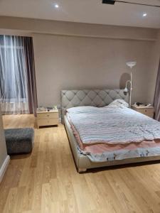 een slaapkamer met een bed en een houten vloer bij Deegii's apartment in Ulaanbaatar