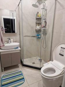 een badkamer met een douche, een toilet en een wastafel bij Deegii's apartment in Ulaanbaatar