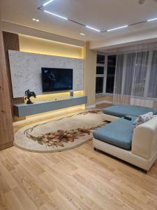 een woonkamer met een bank en een flatscreen-tv bij Deegii's apartment in Ulaanbaatar