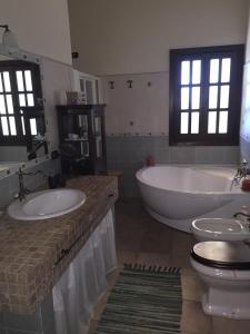 a bathroom with two sinks and a tub and a toilet at B&B Rollo Garden in Ragusa