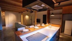 een woonkamer met een tafel en een bank bij Hotel Re:Plug in Kochi
