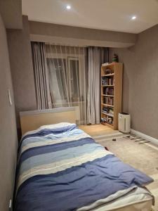 een slaapkamer met een bed en een raam bij Deegii's apartment in Ulaanbaatar