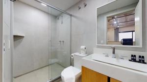 a bathroom with a shower and a sink and a mirror at Charlie Porto Alegre Praça 4 in Porto Alegre