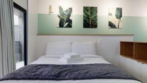 a bedroom with a bed with four pictures on the wall at Charlie Porto Alegre Praça 4 in Porto Alegre