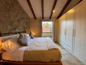 a bedroom with a bed and a stone wall at Loft Arena en ValQuirico in Santeagueda