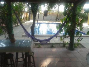 a hammock in the middle of a patio with a pool at Pousada Gincoara in Jijoca de Jericoacoara
