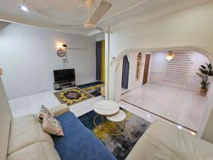 un soggiorno con divano blu e TV di Ruhani Homestay 3 KB - 4 Bedroom Fully Airconditioned with WIFI & Netflix a Kota Bharu
