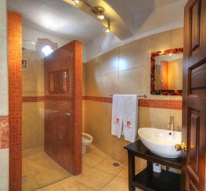 a bathroom with a toilet a sink and a shower at Hotel Agua Escondida in Taxco de Alarcón