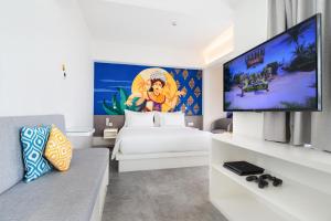 a bedroom with a bed and a flat screen tv at YELLO Hotel Kuta Beachwalk Bali in Kuta