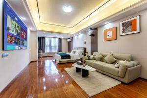 ein Wohnzimmer mit einem Sofa und einem Bett in der Unterkunft East Maple International Apartment - Guangzhou Luogang Wanda Plaza Suyuan Metro Station in Guangzhou