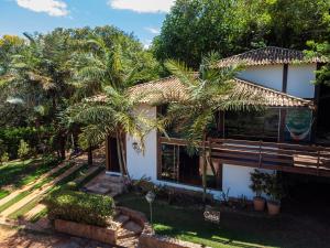 a house with palm trees in front of it at Pousada Casa de Charme in Lençóis