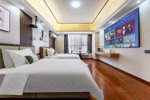 East Maple International Apartment - Guangzhou Luogang Wanda Plaza Suyuan Metro Station في قوانغتشو: غرفه فندقيه سريرين في غرفه