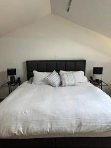 a white bed with two pillows on top of it at Boxwood IXL Lux Hobart Waterfront in Hobart