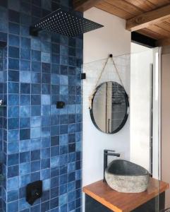 Baño de azulejos azules con lavabo y espejo en Casa con vista a las montañas en Quito