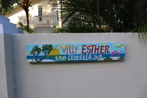 una señal en el costado de una pared blanca en Villa Esther two private rooms in a Vacation Villa near Blue Bay golf and beach resort en Willemstad