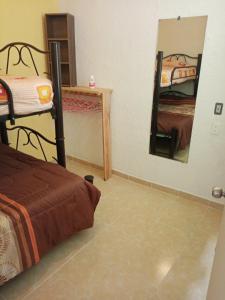 a bedroom with two bunk beds and a mirror at Bonita casa de descanso en Cuautla Morelos in Tlayecac