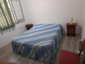 1 dormitorio con 1 cama con edredón azul y blanco en casa-quinta en General Rodríguez